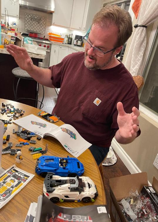 man building lego sets at table