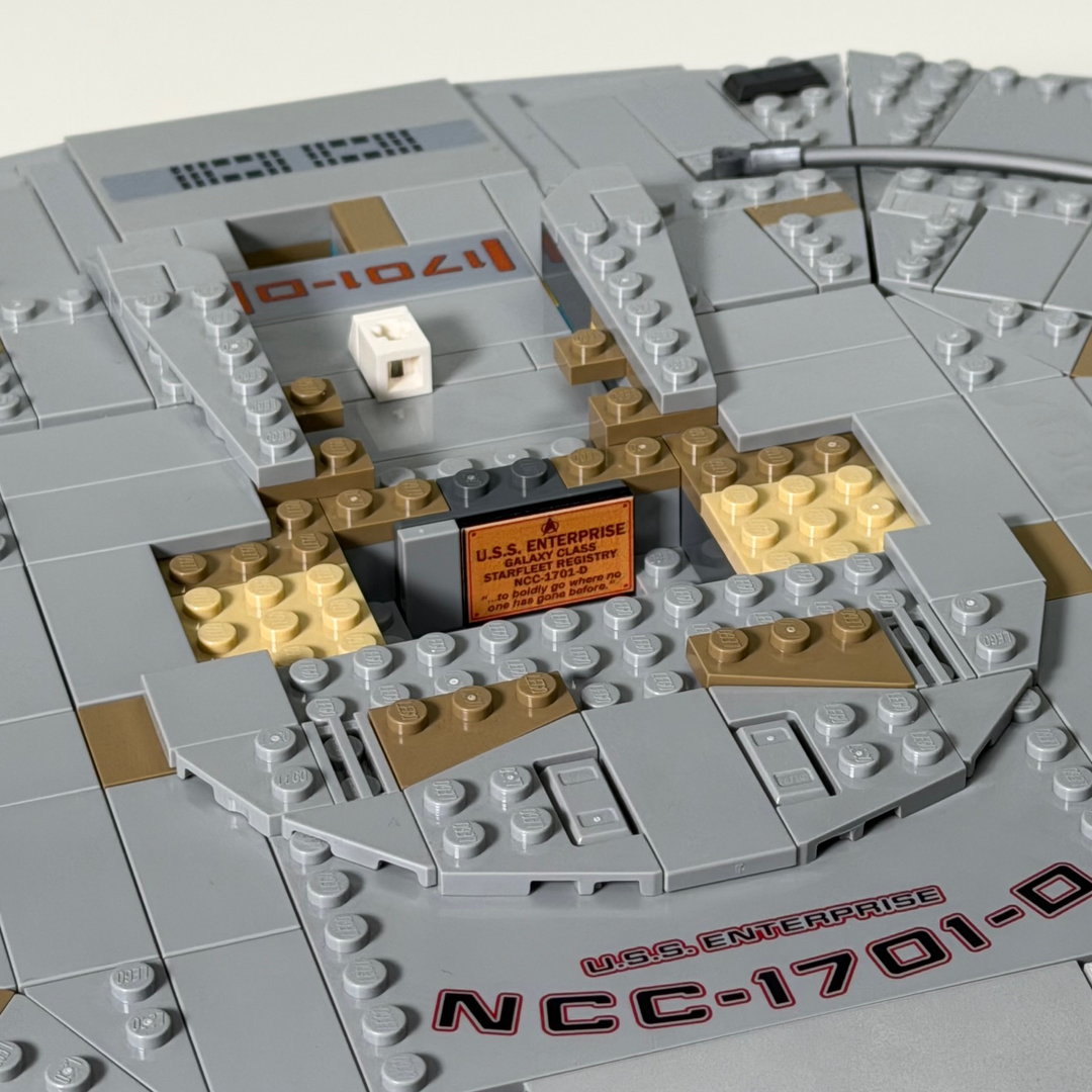 LEGO model of a spaceship with 'U.S.S. Enterprise' branding on a light gray background
